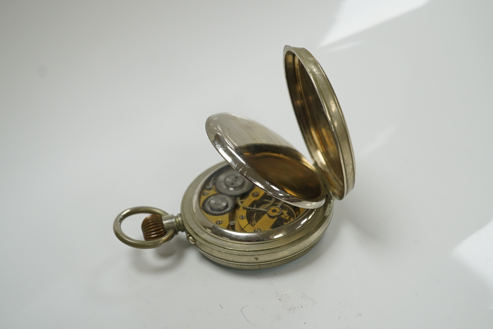 An Edwardian repousse silver mounted travelling watch case, maker W.?, Chester, 1902, 11.1cm, containing a nickel cased pocket watch. Condition - poor to fair